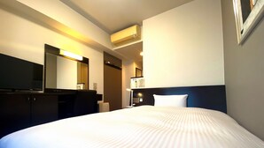 A hotel room with a large bed, a flat-screen TV, a desk, and a mirror.