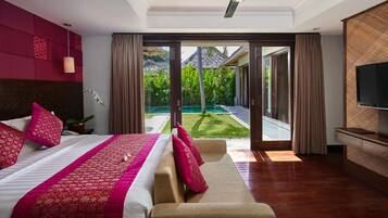 A modern hotel room with a large bed, a sofa, a ceiling fan, and a TV.
