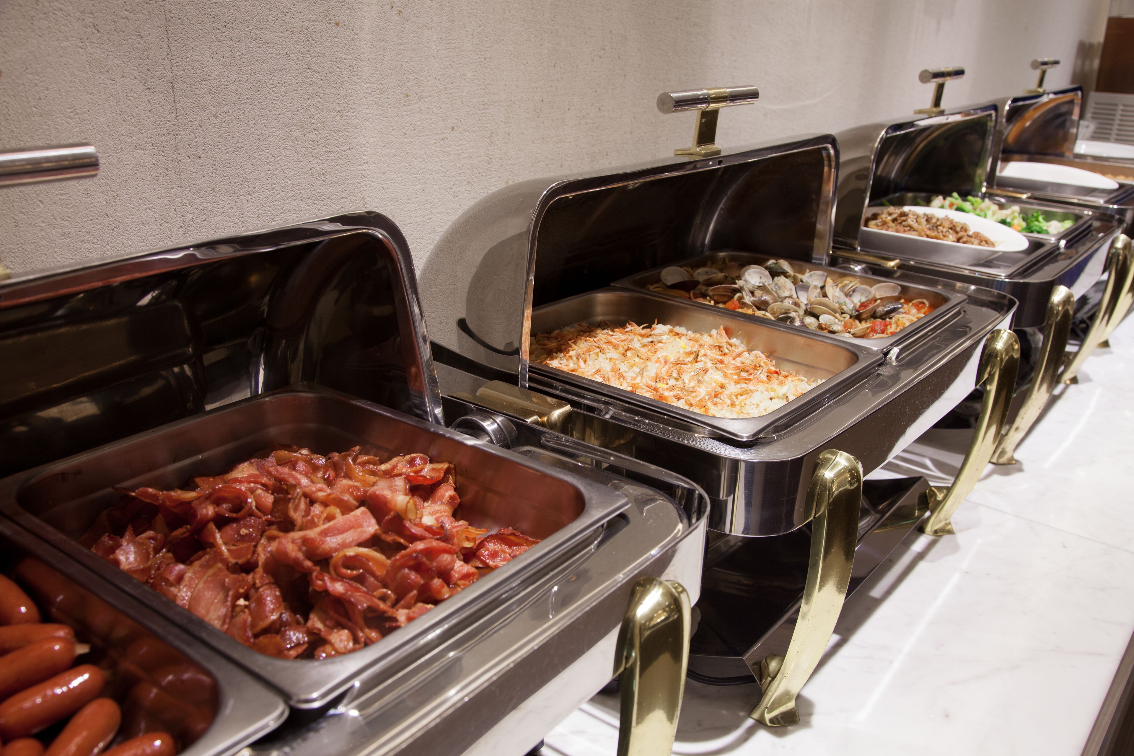 A buffet with various food options including meats and salads.