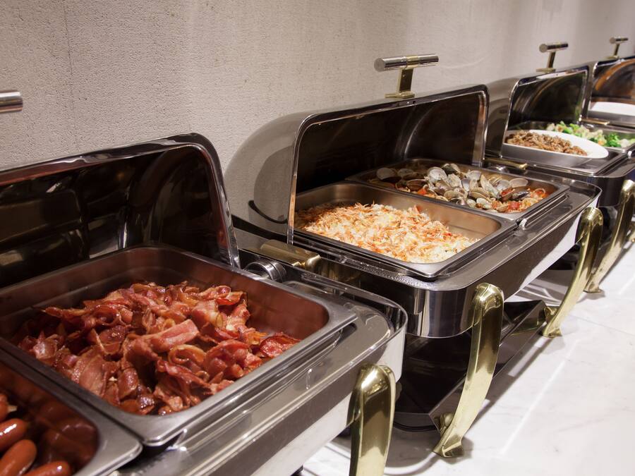 Buffet com diversas opções de comida, incluindo carnes e saladas.