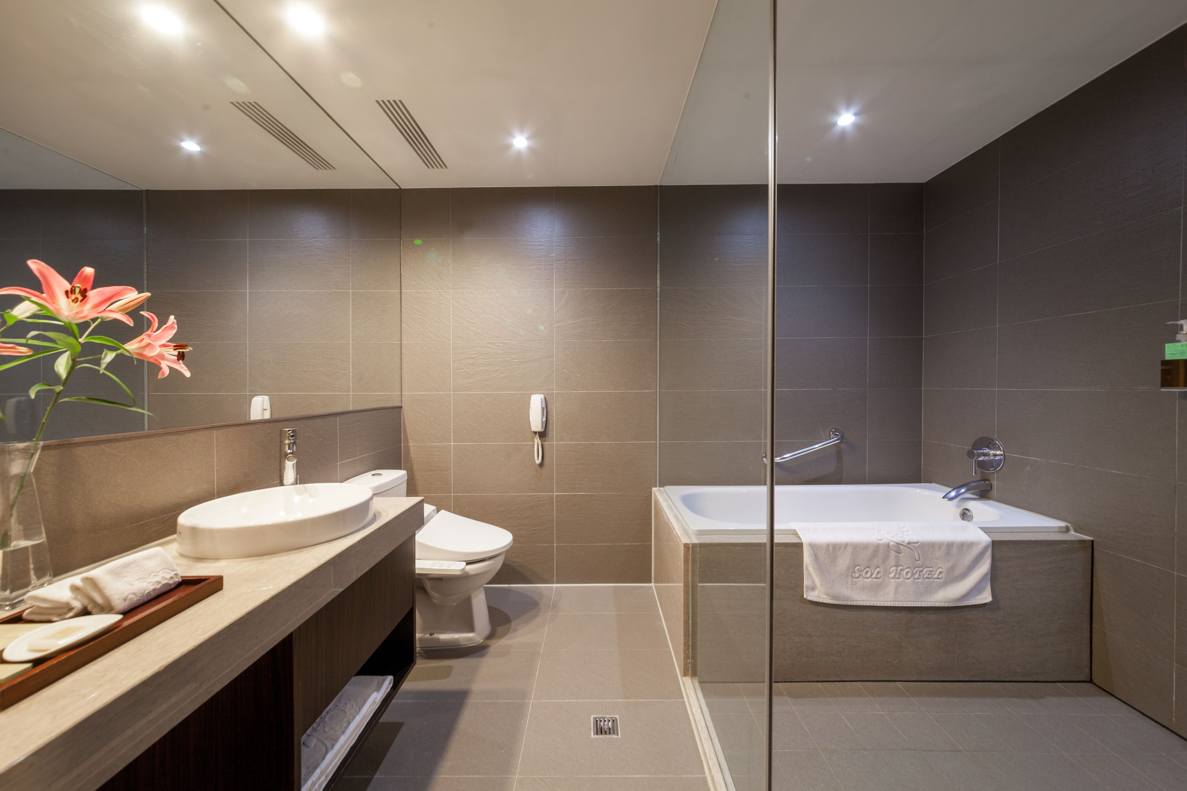 Ein modernes Badezimmer mit Waschtisch, Toilette und Badewanne.