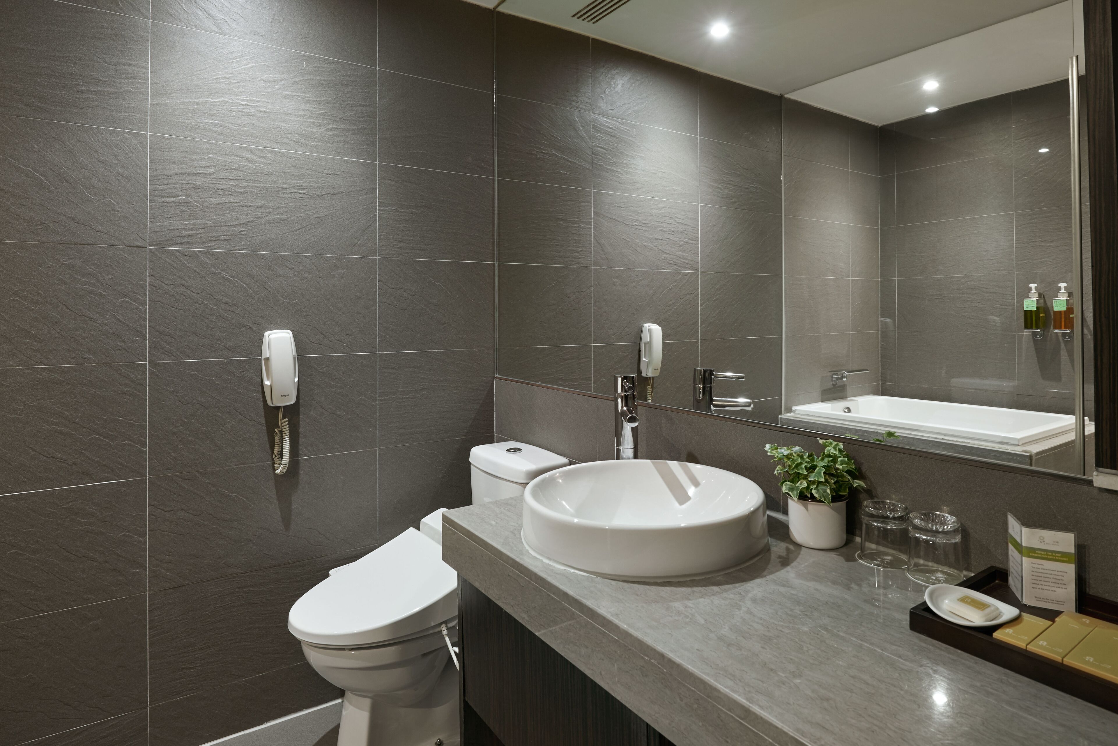 Un baño moderno con inodoro, lavabo y espejo.