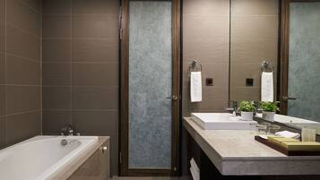 A modern bathroom with a bathtub, two sinks, and a large mirror.