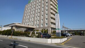 Edifício de hotel com vários andares, fachada plana e numerosas janelas.