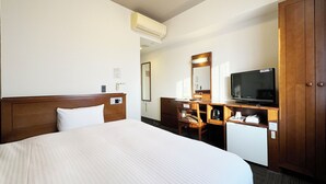 Una camera d'albergo con un letto grande, un comò di legno, una televisione e uno specchio.