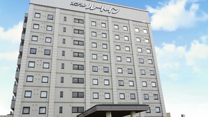 A multi-story hotel with a flat facade, numerous windows, and a covered entrance. - Hotel Route Inn Tsubamesanjo Ekimae (Sanjo)