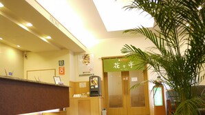 A reception area with a reception desk, a coffee machine, a bulletin board, and a sign with Japanese characters. - Hotel Route Inn Tsubamesanjo Ekimae (Sanjo)