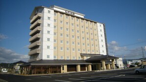 A multi-story hotel with a flat facade, multiple balconies, and a parking lot in front. - Route Inn Grantia Himi Wakuranoyado (Himi)