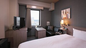 A hotel room with a bed, a desk, a television, a chair, a nightstand, and a window with curtains. - Hotel Route Inn Toyama Ekimae (Toyama)