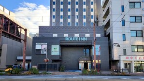 A modern building with a sign reading "ROUTE INN" on the front. - Hotel Route Inn Toyama Ekimae (Toyama)