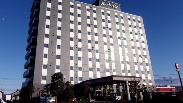 Un hotel de varios pisos con un diseño moderno, que destaca un letrero grande en la parte superior.