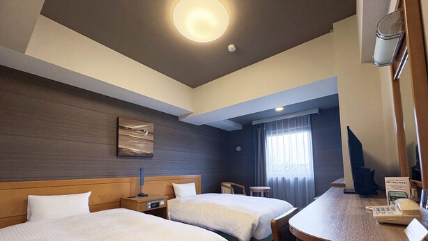 A hotel room with two beds, a desk, a chair, a clock, and a window with curtains. - Hotel Route - Inn Nishinasuno (Nasushiobara)