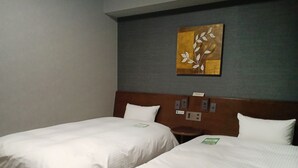 A hotel room with two beds, a wooden headboard, a wall-mounted artwork, and a small bedside table. - Hotel Route Inn Oyama (Oyama)