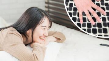 Una persona acostada en una cama con la mano sobre una superficie texturizada.