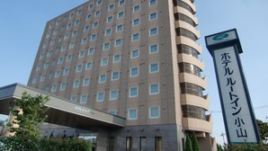 A multi-story hotel with a modern design, featuring a prominent sign with Japanese characters and a logo. - Hotel Route Inn Oyama (Oyama)
