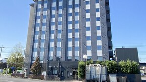 Un immeuble moderne et imposant, doté d’une façade à motifs géométriques et d’une enseigne au sommet.