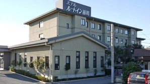 A multi-story building with a sign indicating it is a hotel. There are multiple windows on the facade, and a car is parked in front. - Hotel Route-Inn Court Fujioka (Fujioka)