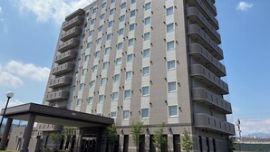 A multi-story hotel with a modern design, featuring a prominent entrance and a series of balconies. - Hotel Route Inn Shibukawa (Shibukawa)