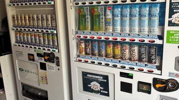 Two vending machines with various beverages and snacks, including options like soda, energy drinks, and bottled water.
