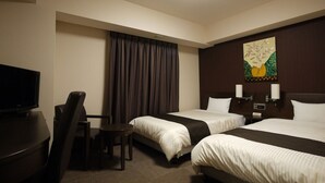 Une chambre d’hôtel avec deux lits, un bureau, une chaise, une télévision et un tableau au mur.