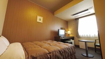 Quarto de hotel com cama, escrivaninha, televisão e janela com cortinas.