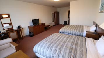 A hotel room with two beds, a desk, a chair, a television, and a bedside table.