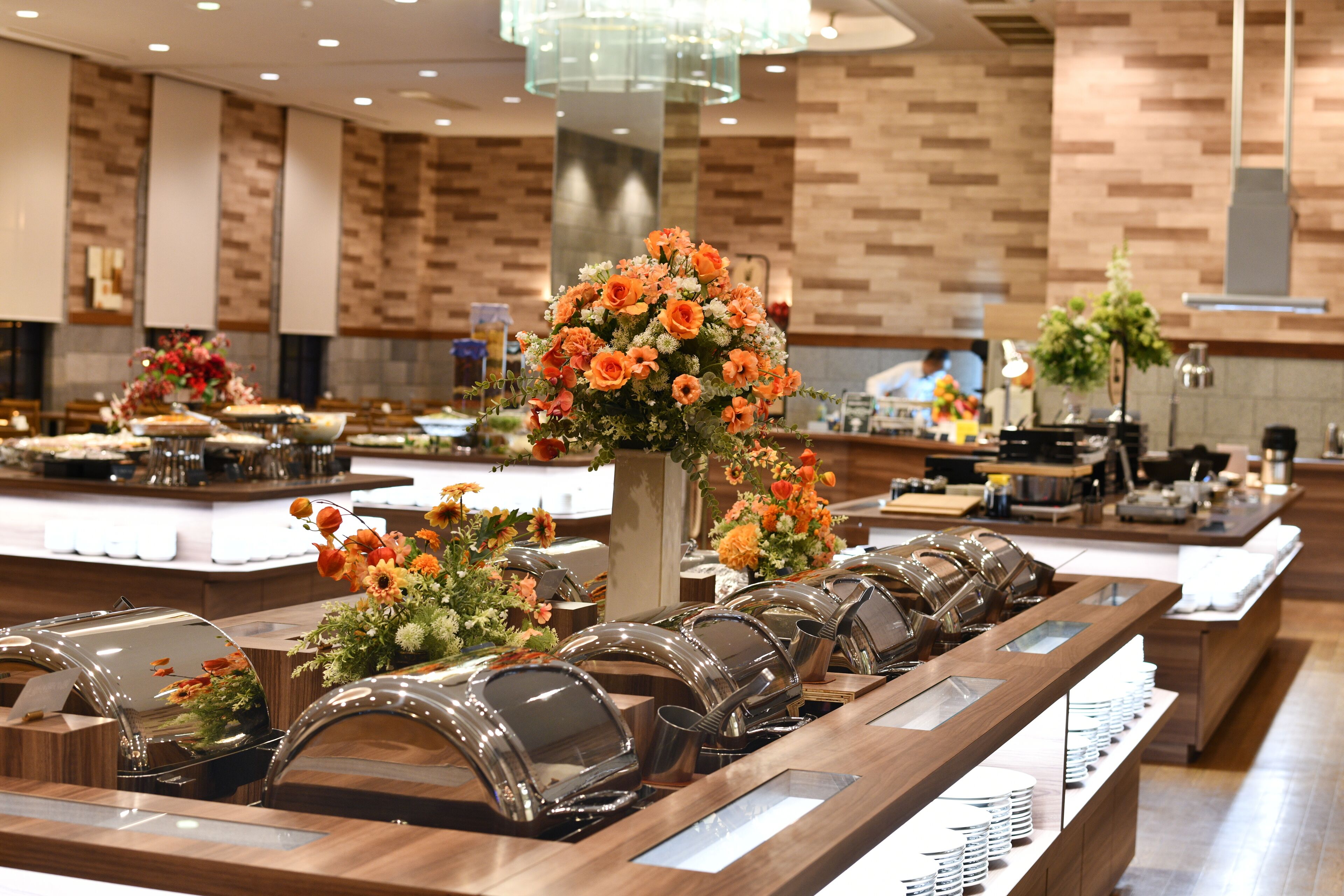 Un buffet composé de plusieurs tables de service, chacune étant recouverte d’un couvercle en verre en forme de dôme et agrémentée d’un arrangement floral.