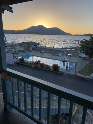 A pool area with a view of the sea and mountains at sunset. - Lamplighter Motel (Clearlake)