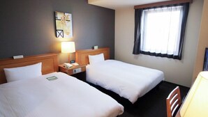 A hotel room with two single beds, a nightstand with a lamp, a painting on the wall, and a window with curtains.