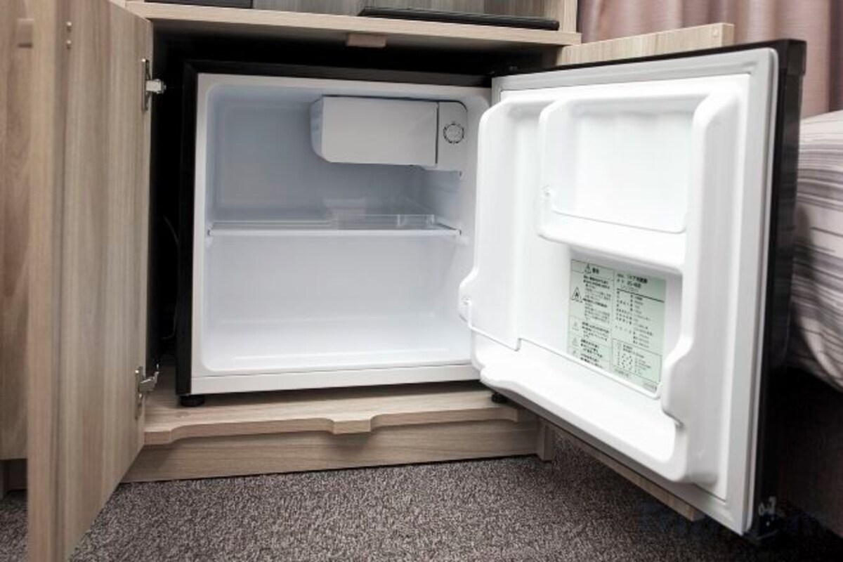 Un réfrigérateur ouvert, avec un panneau de commande situé sur le côté droit.
