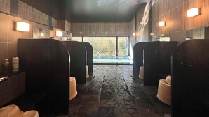 A public restroom with two sinks, a mirror, and a window providing a view of an outdoor area.