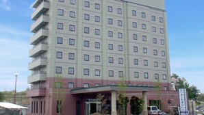 Un hôtel à plusieurs étages, doté d’une façade sobre, de nombreuses fenêtres et d’une enseigne indiquant qu’il s’agit d’un hôtel.