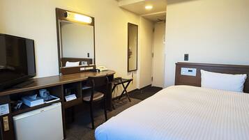 A hotel room with a bed, a desk with a chair, a television, a mirror, and a mini-fridge.