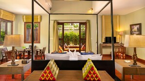 A hotel room with a four-poster bed, a television, and a dining area with a table and chairs. - GZ Eden Privilege Resort and Spa (Siem Reap)