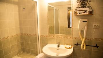 Un baño con bañera, lavamanos, espejo y toallero.