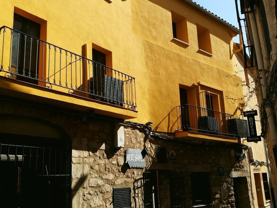 Un edificio amarillo con balcones y fachada de piedra.