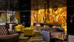 A modern lounge area with a fireplace, comfortable seating, and a patterned carpet. - Sura Design Hotel and Suites - Boutique Class (Istanbul)