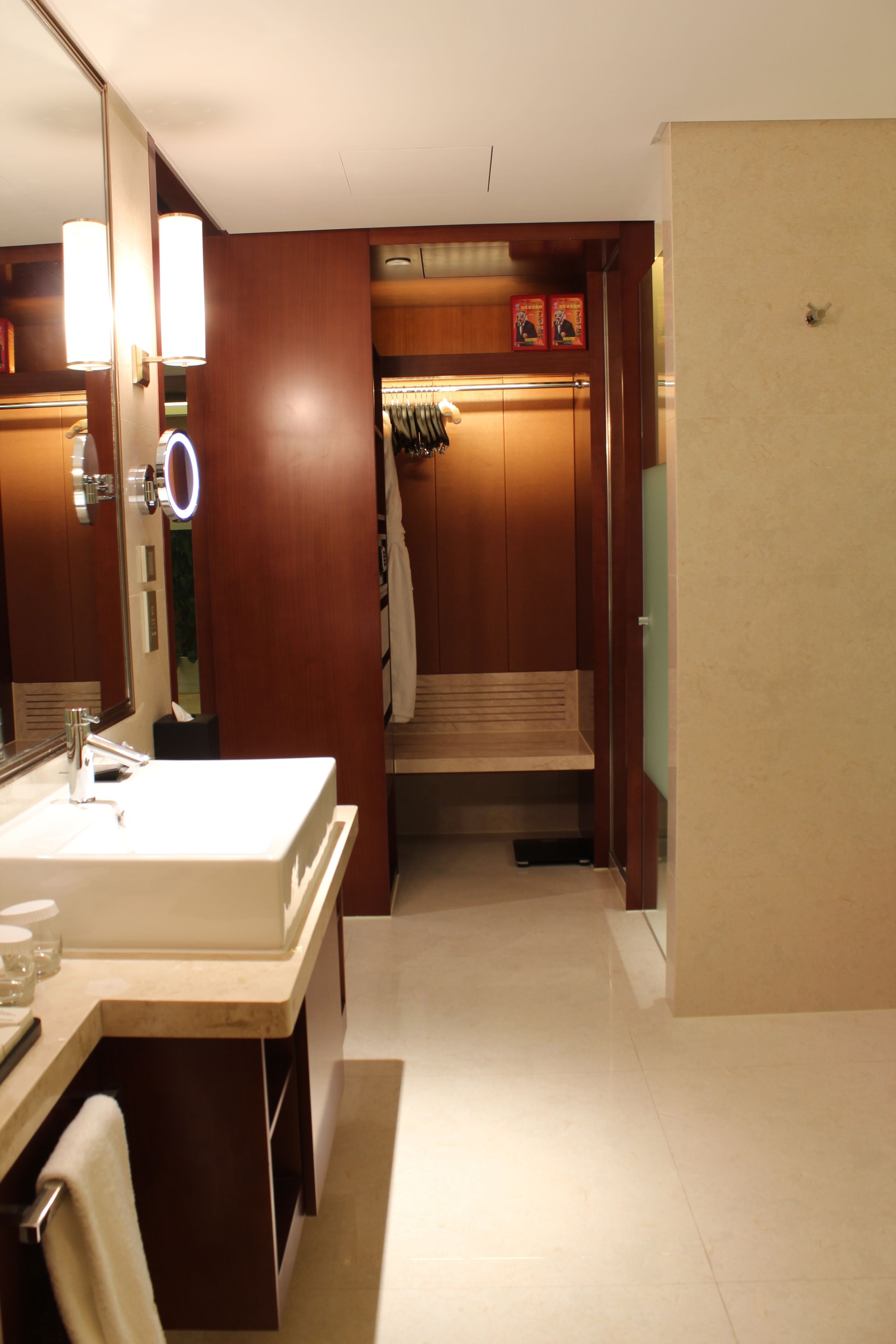 A hotel bathroom with a large mirror, a sink, and a towel rack.