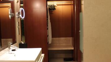 A hotel bathroom with a large mirror, a sink, and a towel rack.