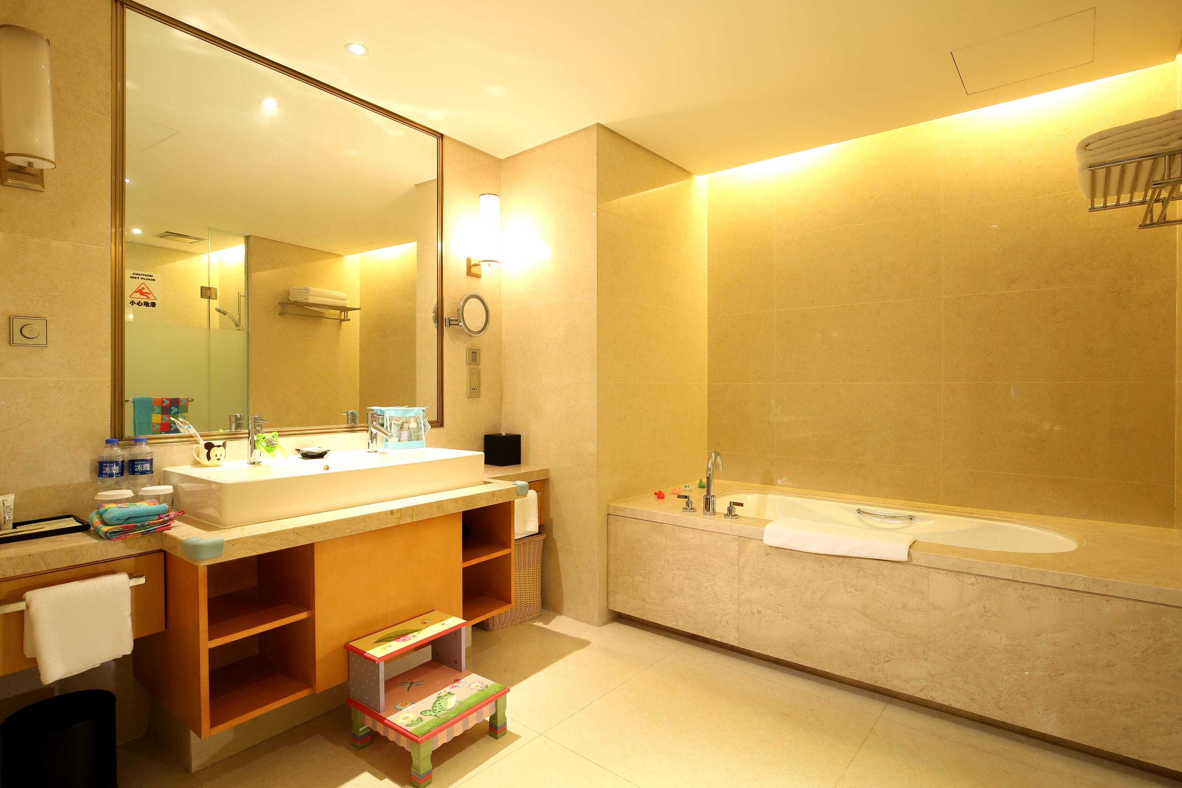 A modern bathroom with two sinks, a large mirror, and a bathtub.