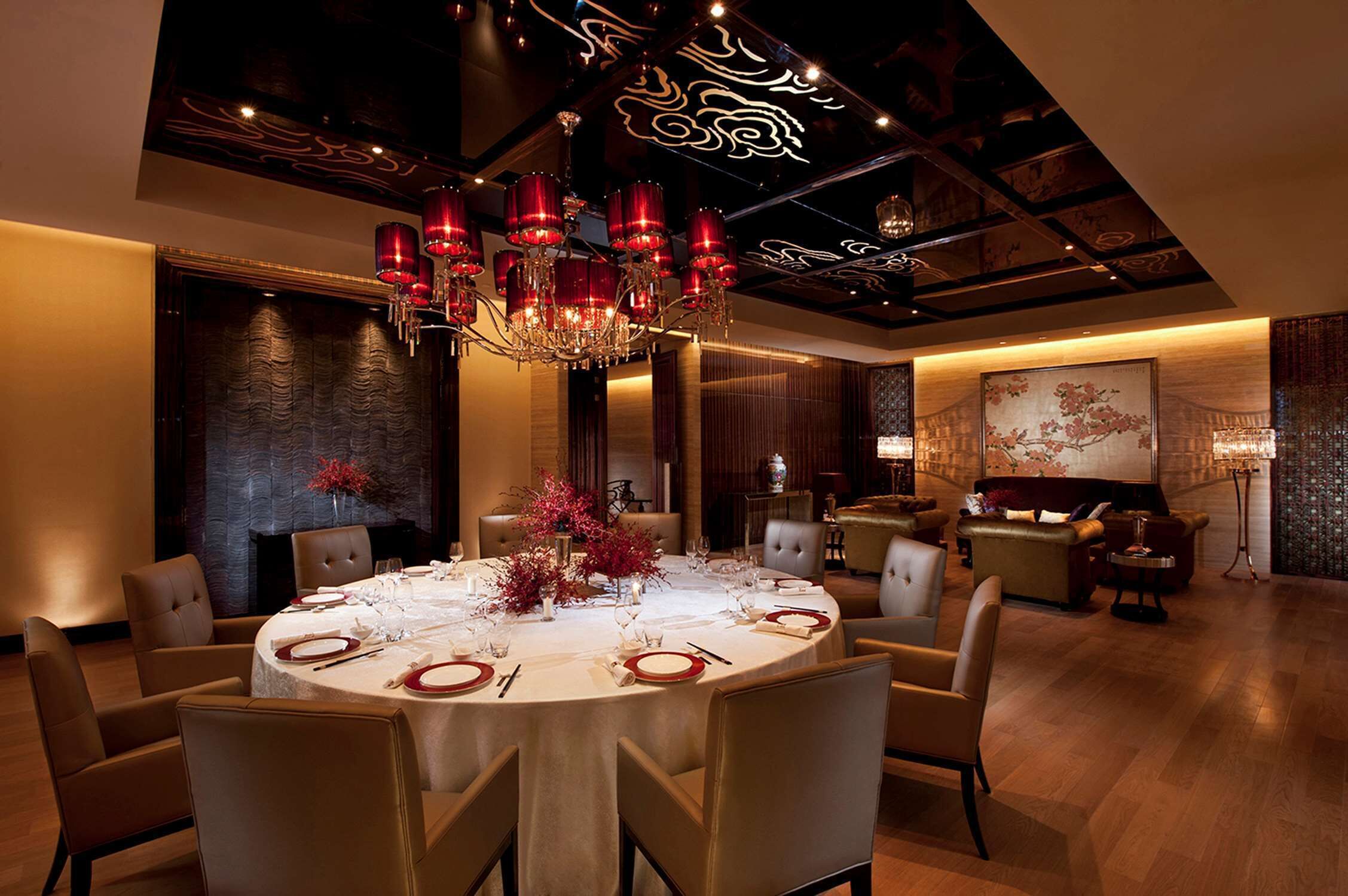 A dining area with a round table set for six, surrounded by six chairs.