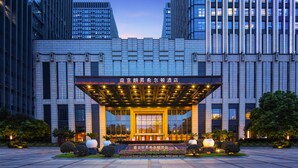 A modern hotel entrance with a covered lobby, large windows, and a well-lit facade. - Hilton Nanjing (Nanjing)