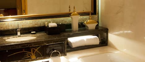 A modern bathroom with a large mirror, a bathtub, a sink, and a vanity.