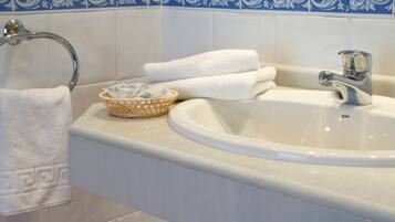 Un baño con un lavabo blanco, un perchero para toallas y un salpicadero decorativo con azulejos azules y blancos.
