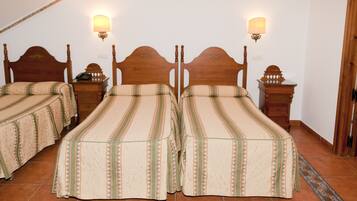 A room with two wooden beds, each with a headboard and footboard, and two bedside tables with lamps.
