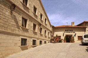 Um edifício histórico com fachada de pedra, uma placa com a inscrição 