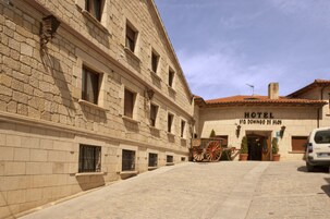 Um edifício histórico com fachada de pedra, uma placa com a inscrição 