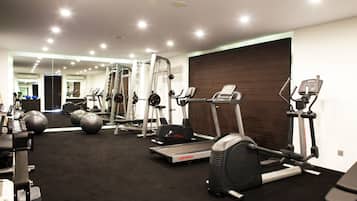 A gym with treadmills, elliptical machines, and exercise balls.