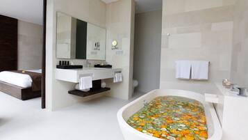 Un baño moderno con una bañera grande, un tocador con espejo y un inodoro.