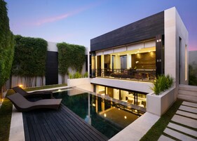 Une maison moderne dotée d’une piscine, d’une terrasse et d’un espace bar.